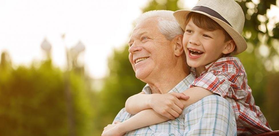Abuelos sonriendo y abrazando cariñosamente a sus nietos